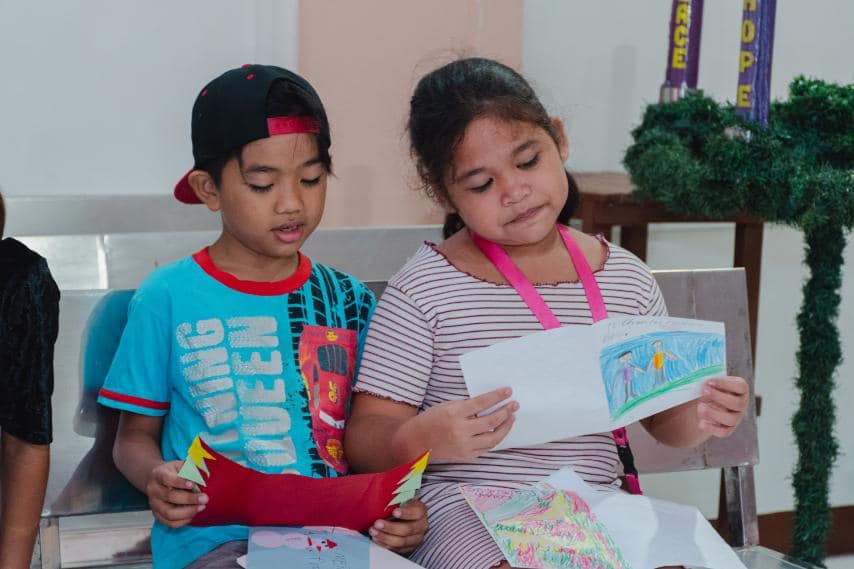 Recipients read Christmas cards made by AGS boys