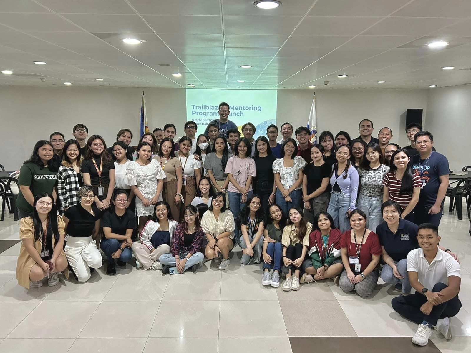 In two rows, students and their mentors huddle for a picture.