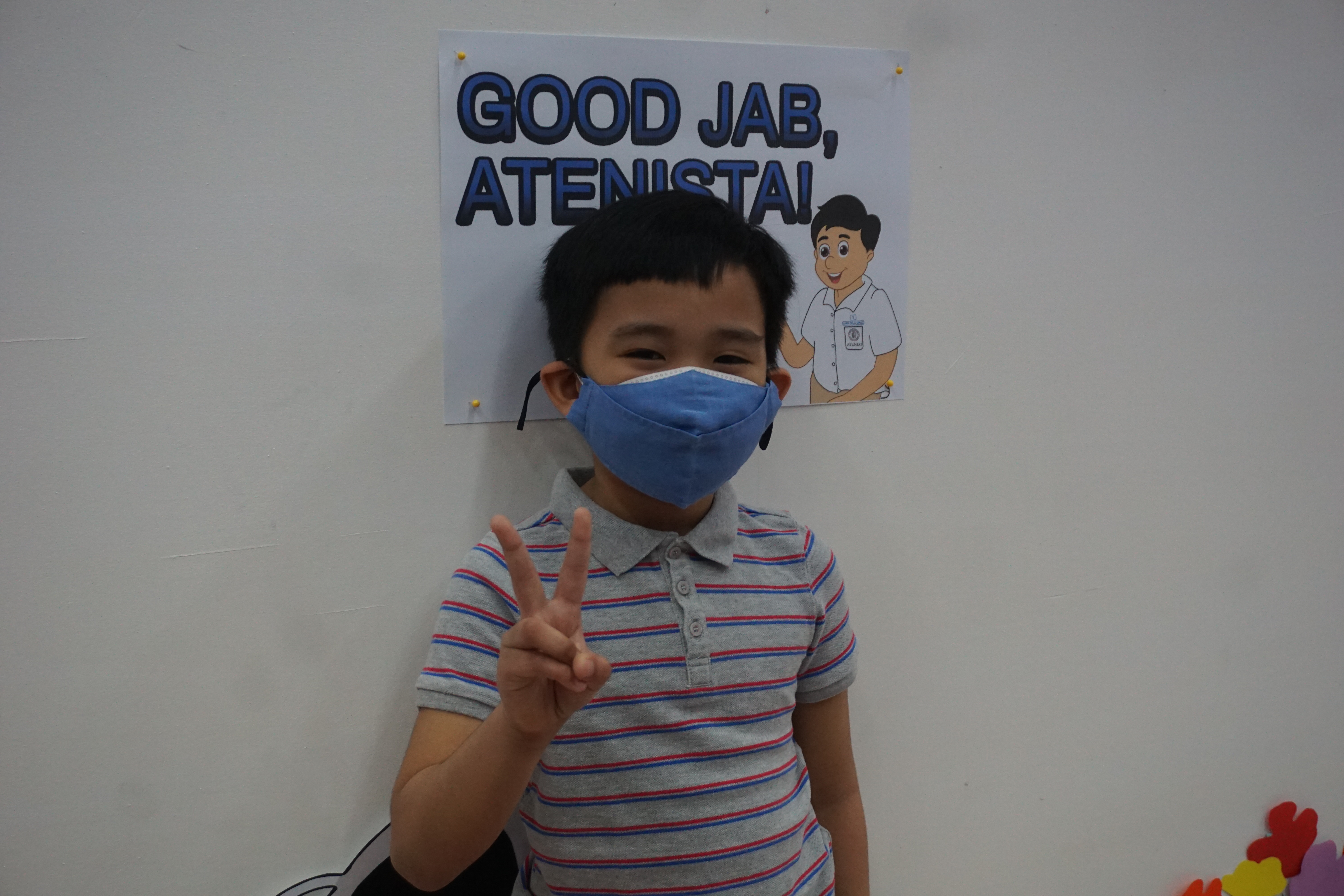 Martin, grade 2, says the injection "was great" but that it "kinda hurt." He appears to be smiling even with his mask on.