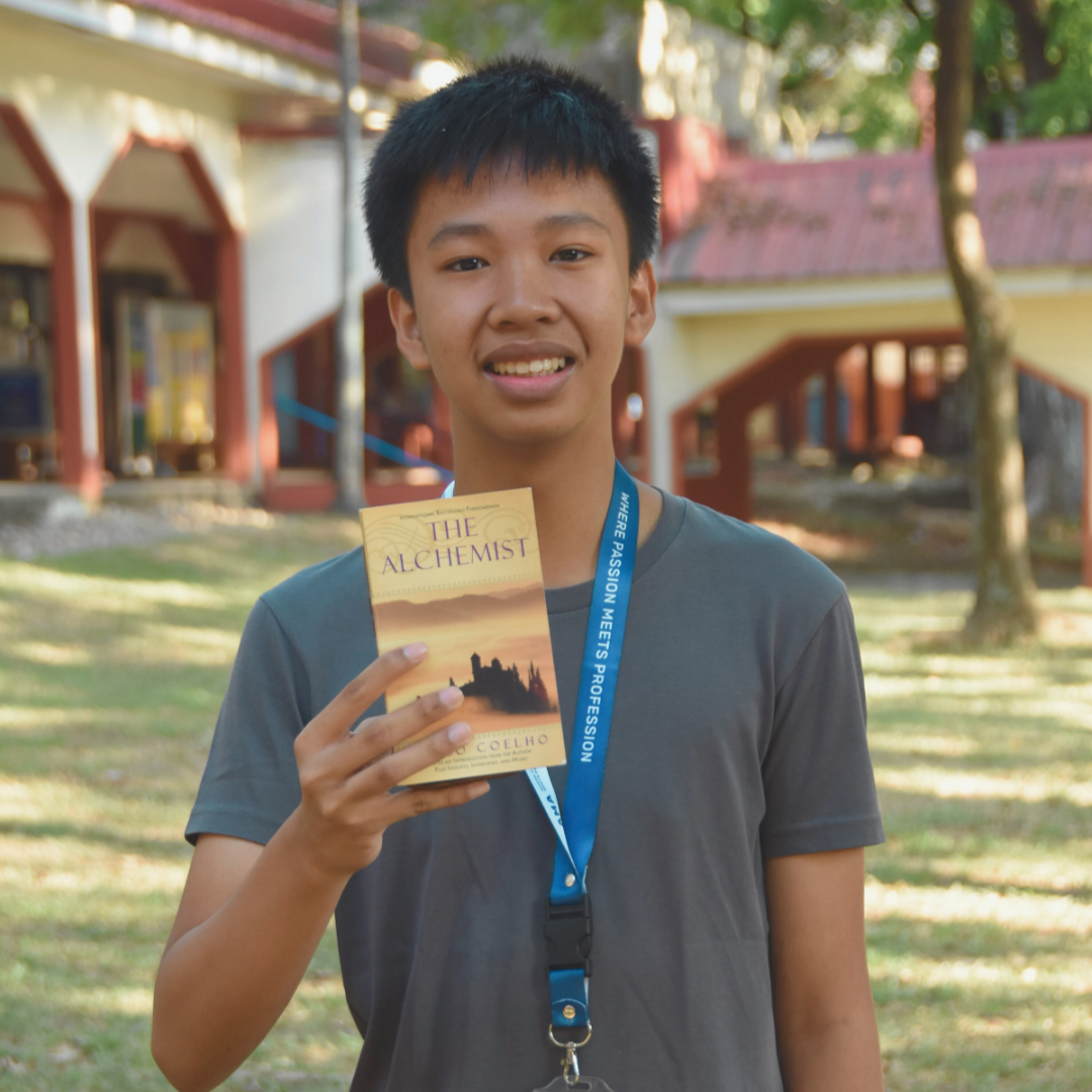 Jesu Manzano poses with a copy of The Alchemist