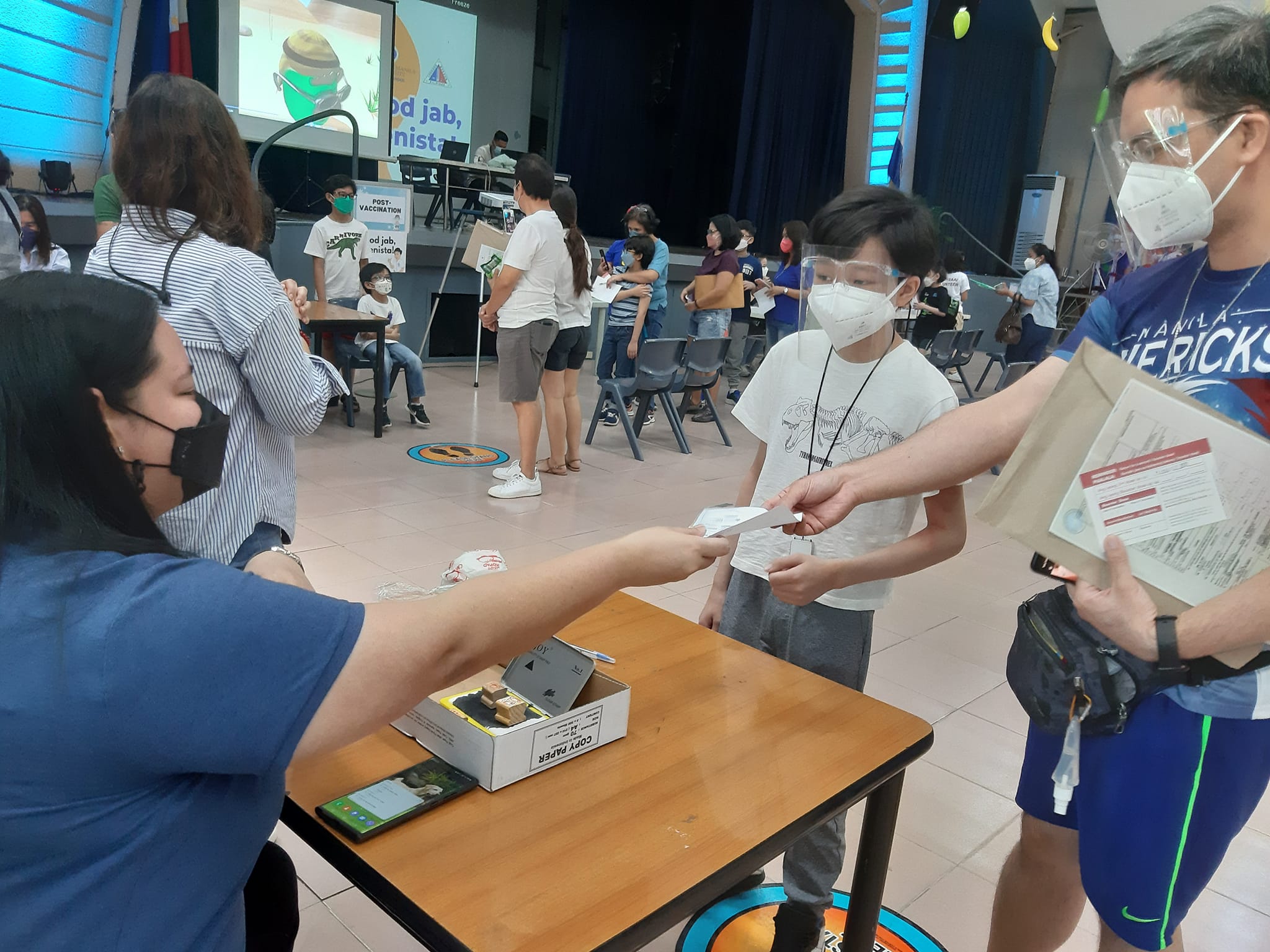 Carlisle, grade 6, has his "vaccine passport" stamped. He says the shot was "good" and that he felt "no pain."