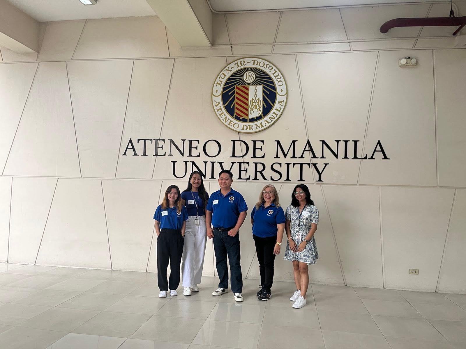 The Ateneo de Naga University’s Office of Alumni Relations (ADNU-OAR) team poses in front of the Ateneo de Manila University seal at the Leong Hall.