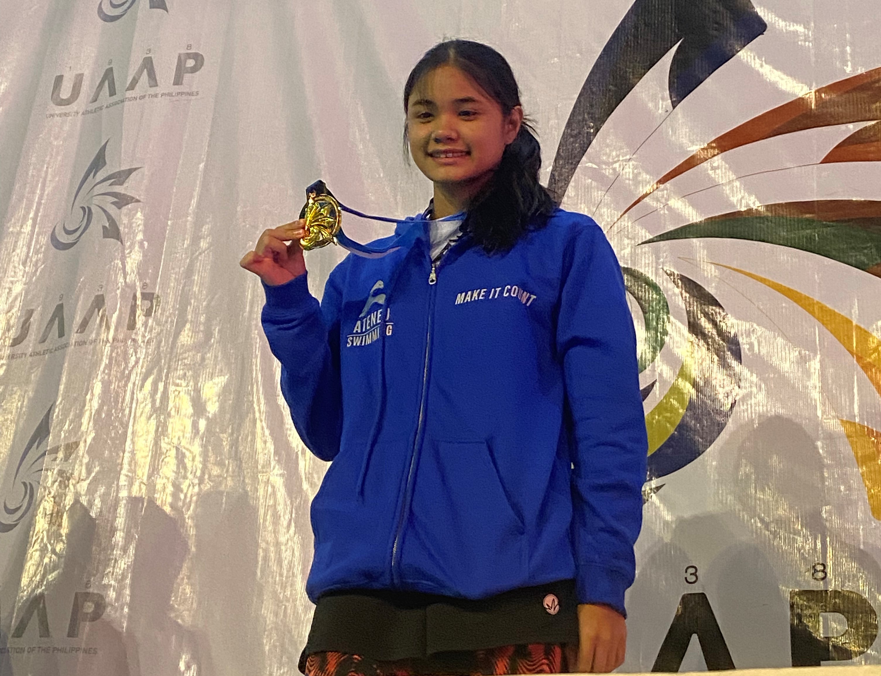 Lora Amoguis with one of the seven gold medals she won at UAAP 85