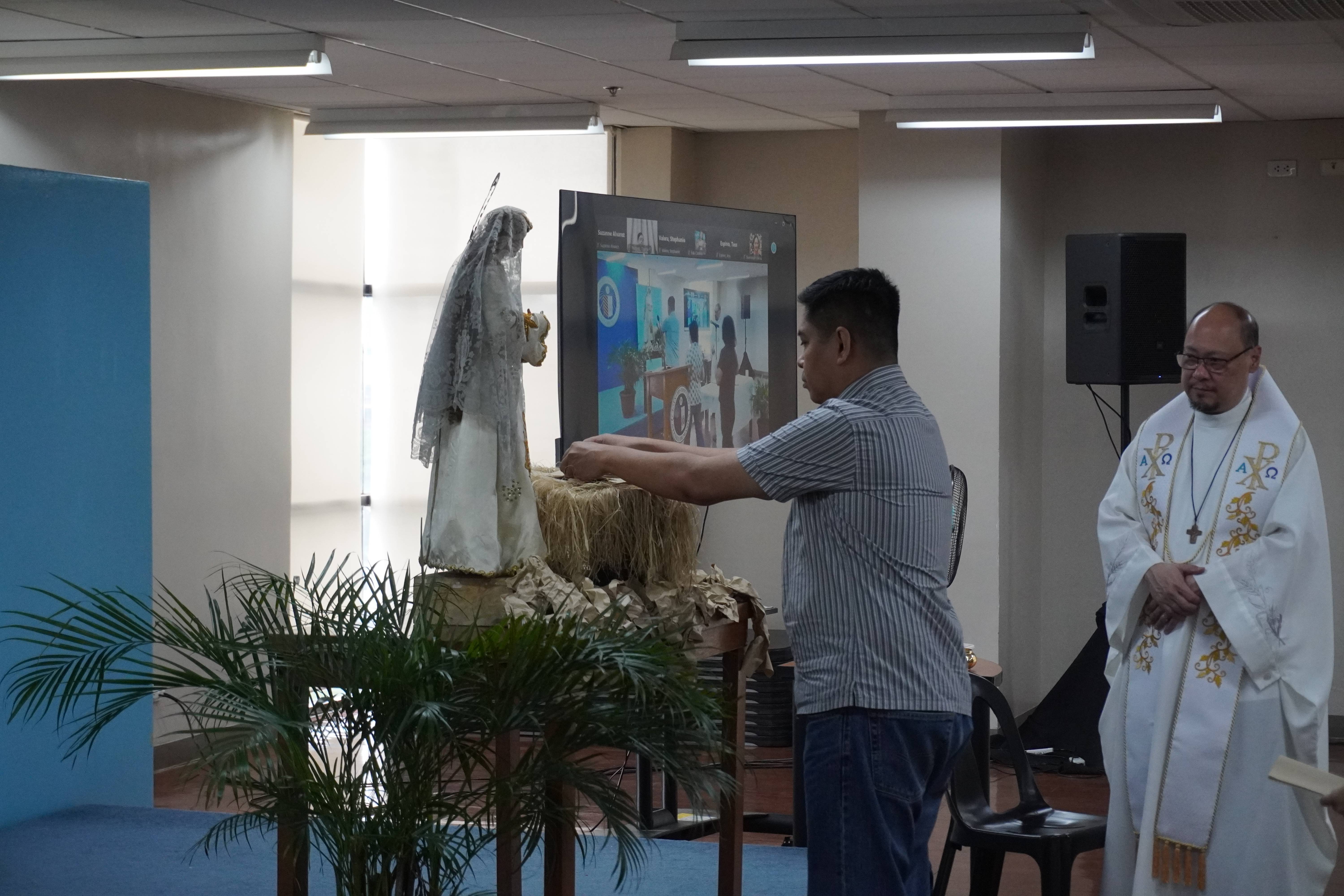 A retreatant offers his hopes in the manger during the Mass.