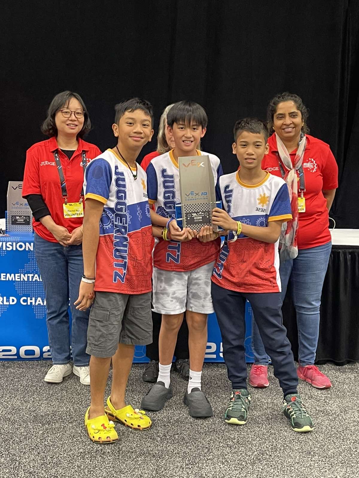 Front row from left: Axl Alingog, Miggy de Guzman, and Dylan Navarrete onstage with their VEX trophy