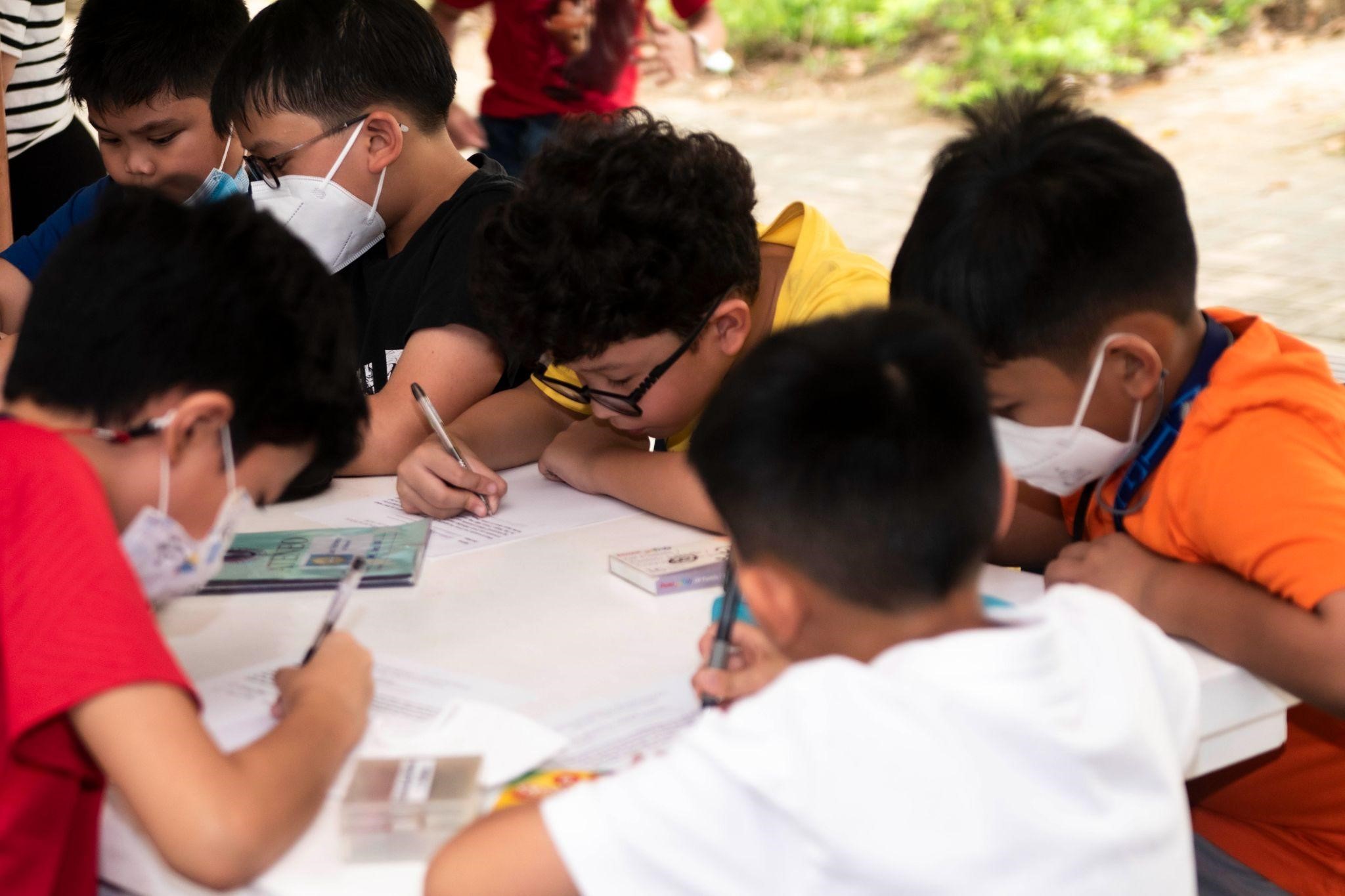 Grade 4 boys putting to paper their thoughtful reflections