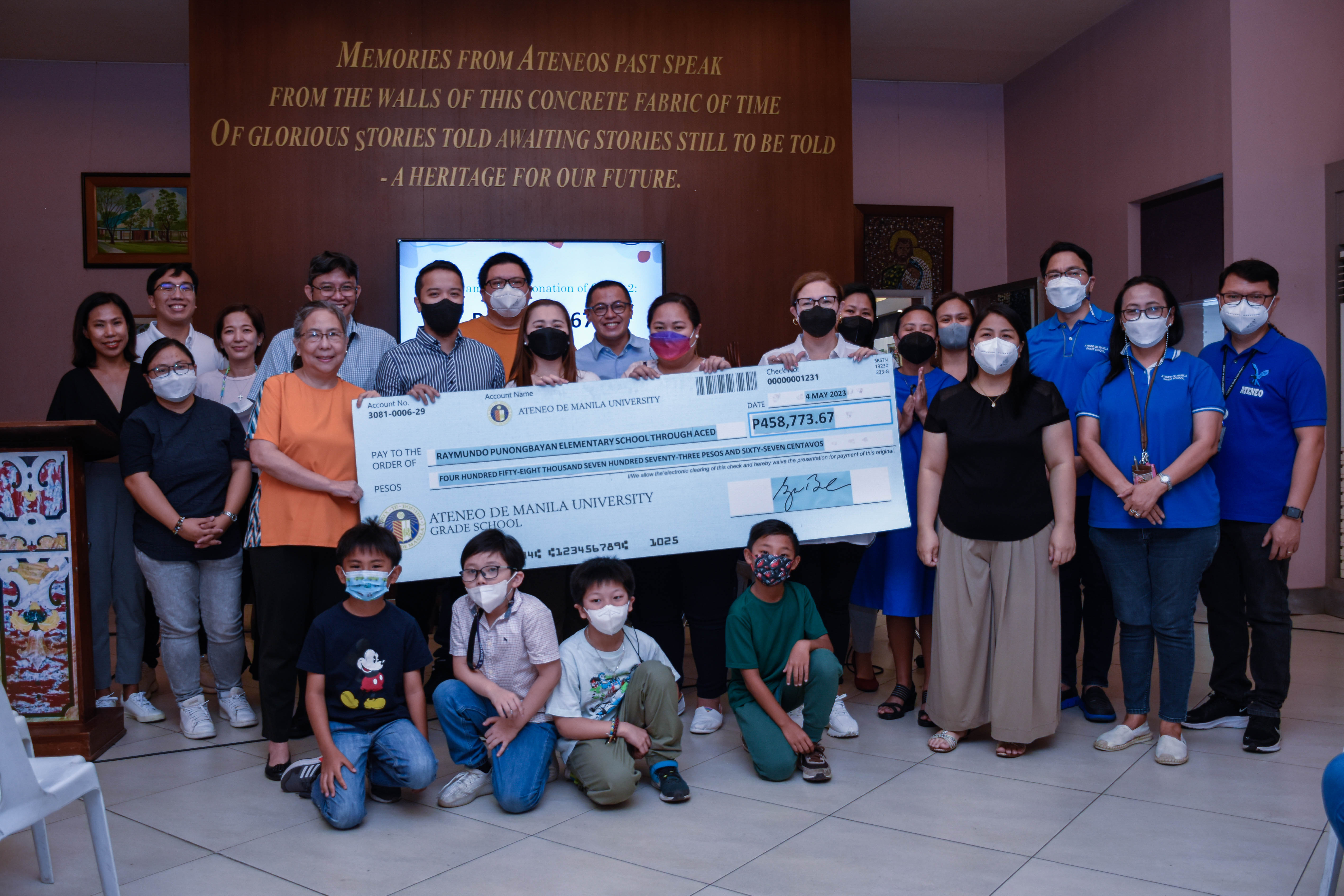 ACED Director Dr. Mel Oracion (in orange blouse to the left of the giant check) with AGS administrators, faculty, students and CPRs during the turnover ceremony