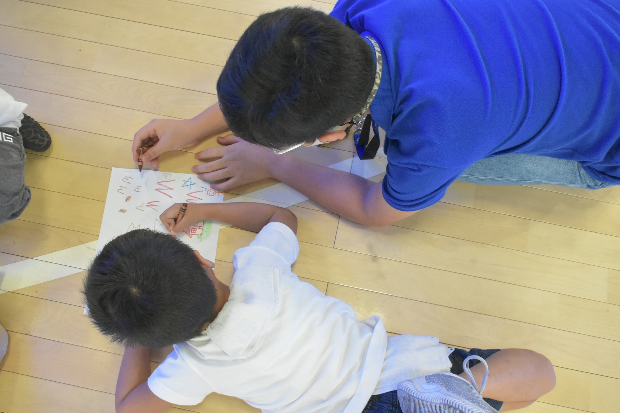 A student from 7 Alfonso drawing with a child from the Day Care Center of Barangay Escopa 3