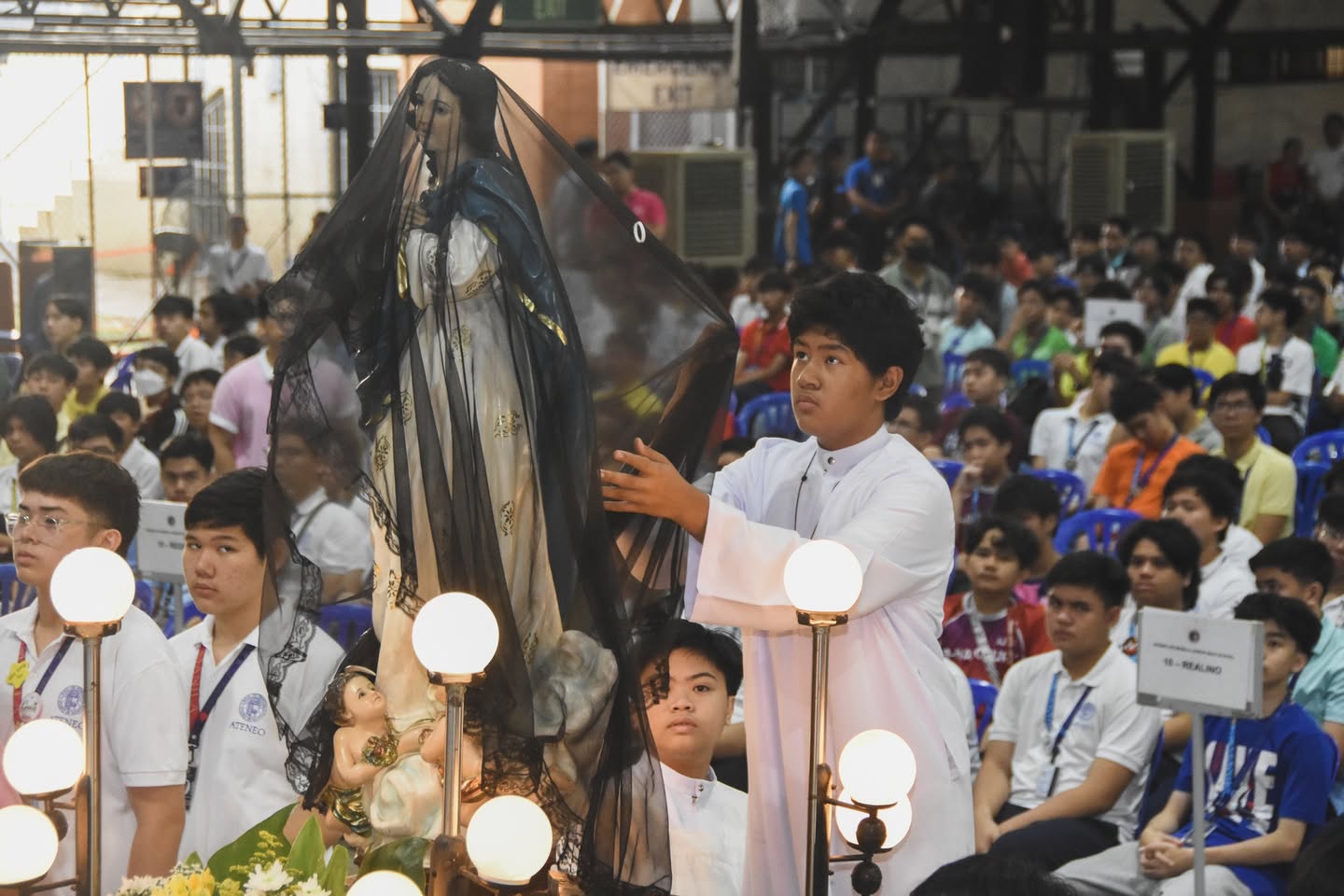 An altar server unveils the image of the Blessed Virgin Mary during the 'Salubong,' rejoicing in the victorious meeting of the Risen Christ and His Mother.