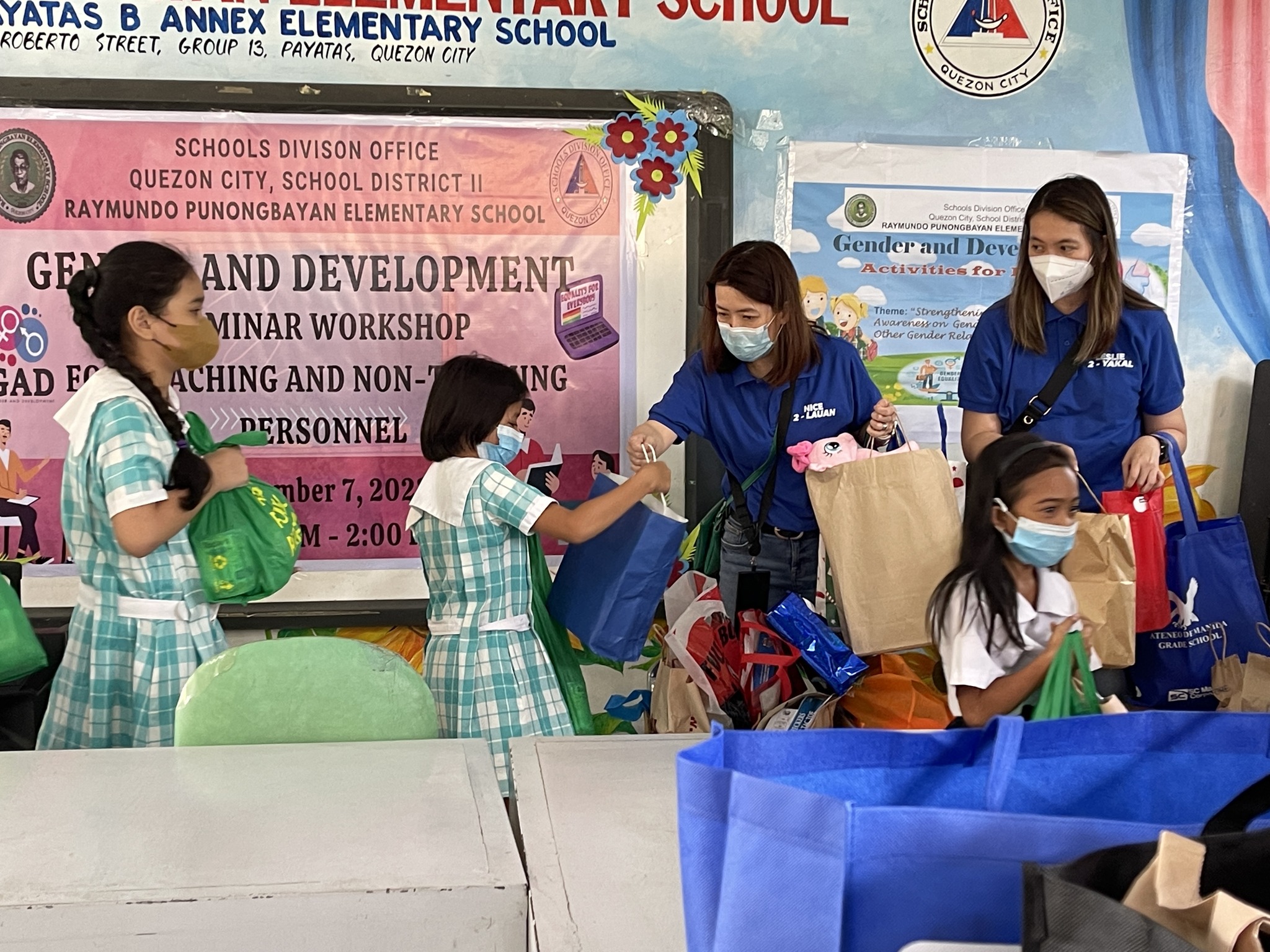 Parents of Grade 2 Ateneans distributing gifts to students of Raymundo Punongbayan Elementary School (RPES)