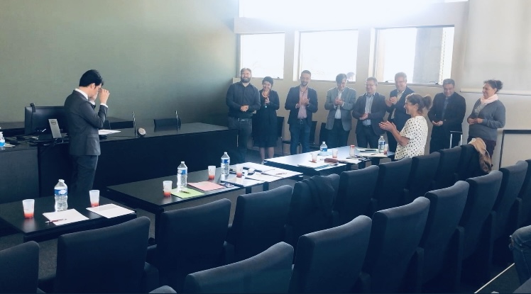 The president and members of the jury (left) applauding  Dr. Peña (right) after a successful thesis defense