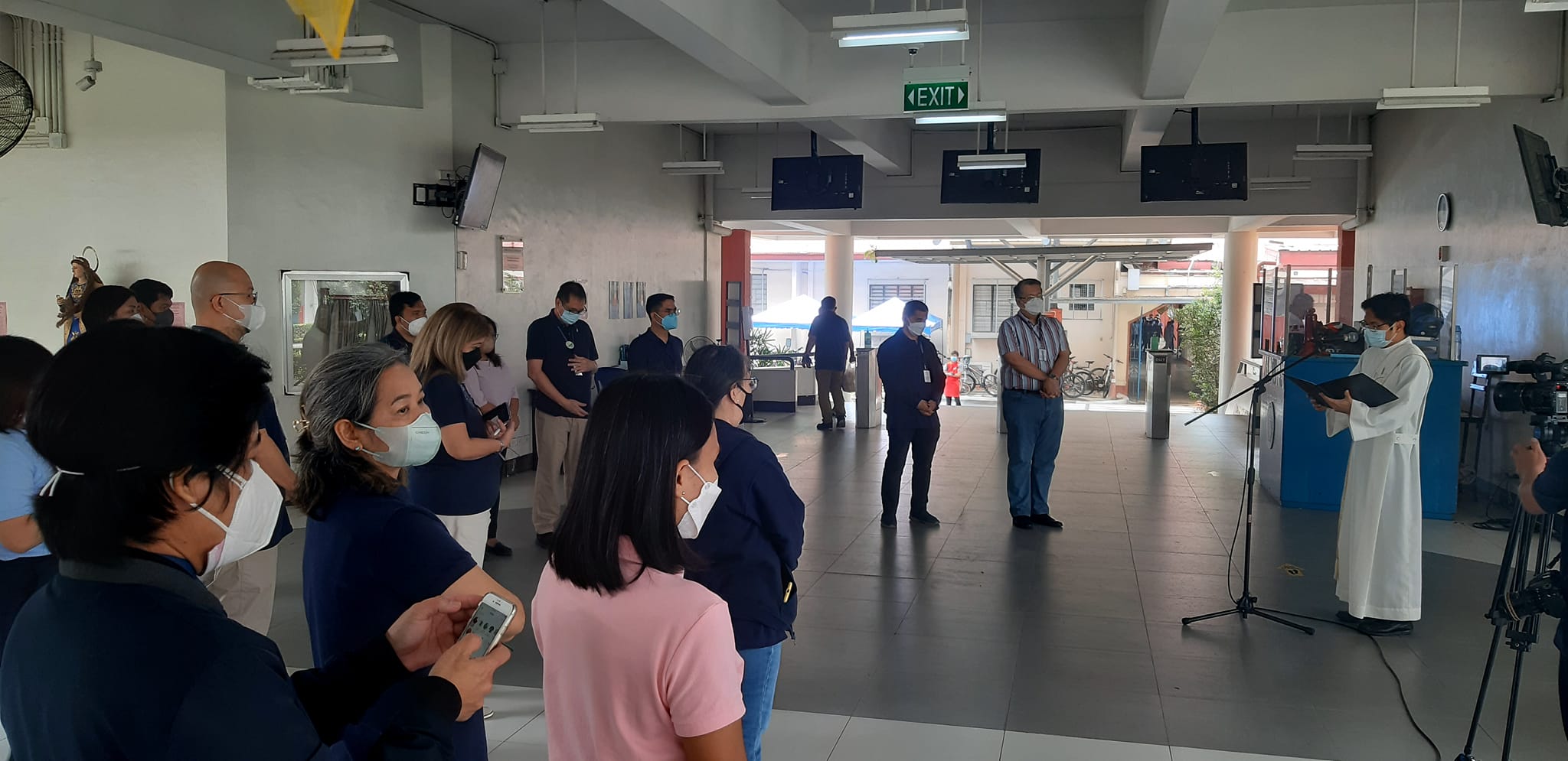 Administrators, faculty and staff listen to Rev. Carlo Lacang SJ (right) as he explains the rite of blessing.