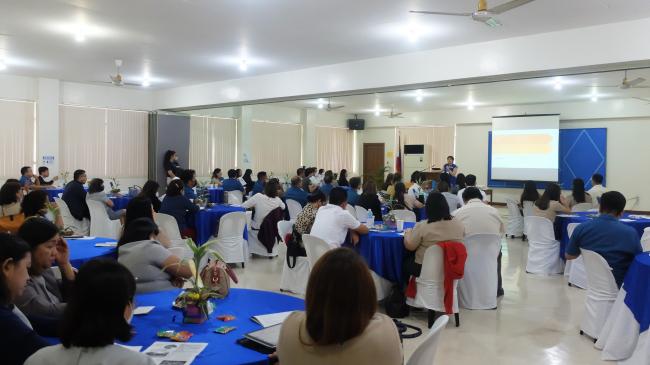 Teachers surrounding conference tables listen to Pathways Director, Solvie Nubla-Lee, speak about the Pathways programs.