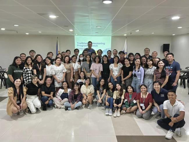 Students and mentors huddle in a semi-circle for a picture
