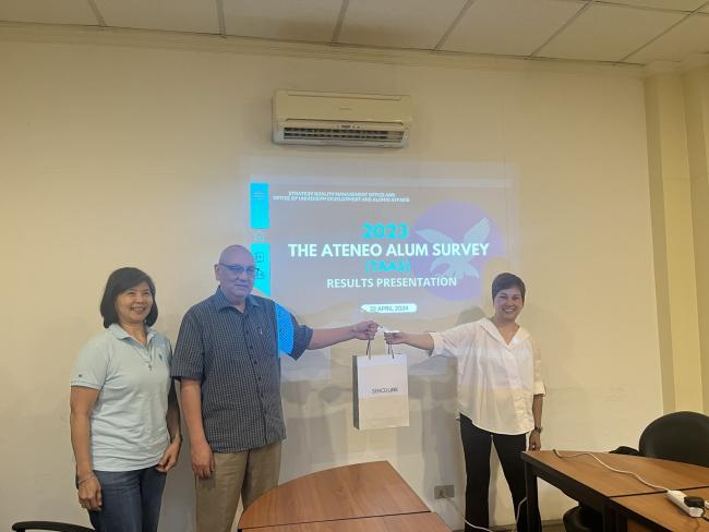 Director of OUDAA Fr. Norberto ‘Kit’ Bautista SJ (middle) and Quality Management and Accreditation Head Ms. Ma. Resurreccion Alejo (right) and  Director of SQMO Ms. Ma. Rosario Banzon (left) holds the seven pairs of Airpods Pro that were given to six TAAS participants.