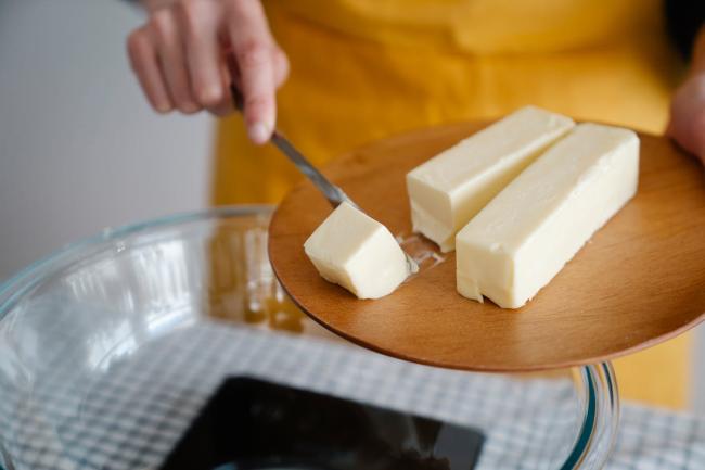 Butter being cut and put into a bowl