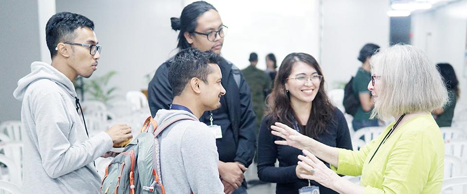 Students engaged in conversation with a professor